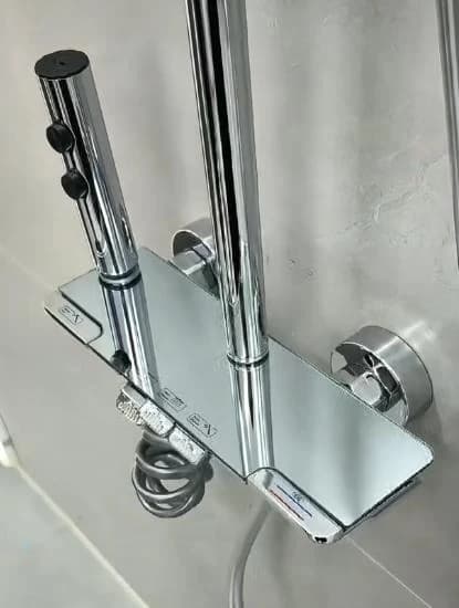 Columna de ducha cromada con repisa de vidrio y botonera