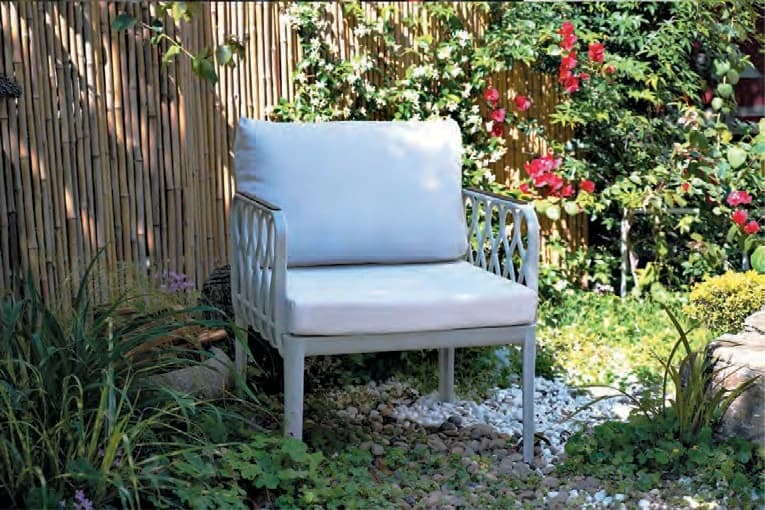 Sillón con brazos calados y almohadones