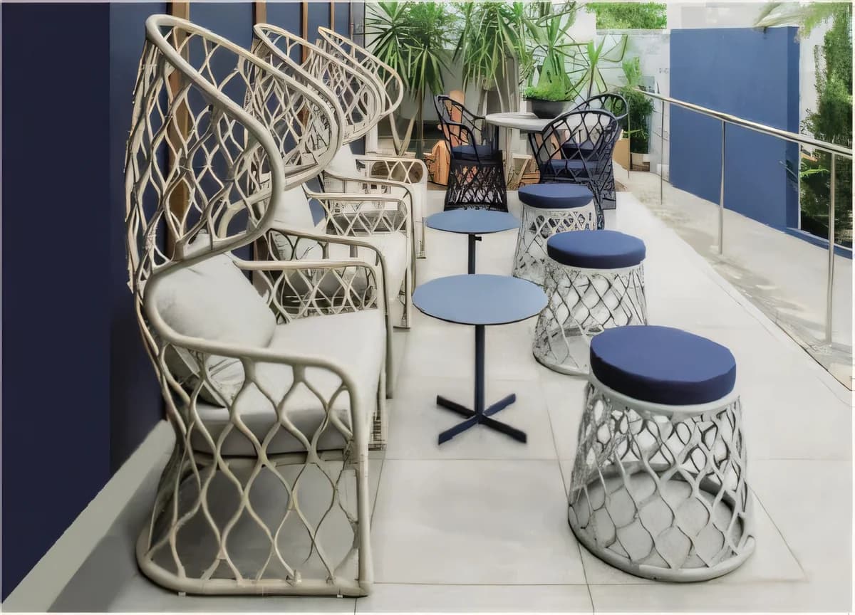 Sillón tejido de respaldo alto con banquetas tejidas