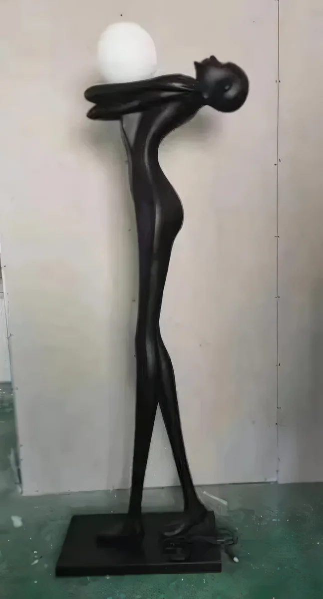 Escultura de figura estilizada inclinada con esfera blanca, 180 cm