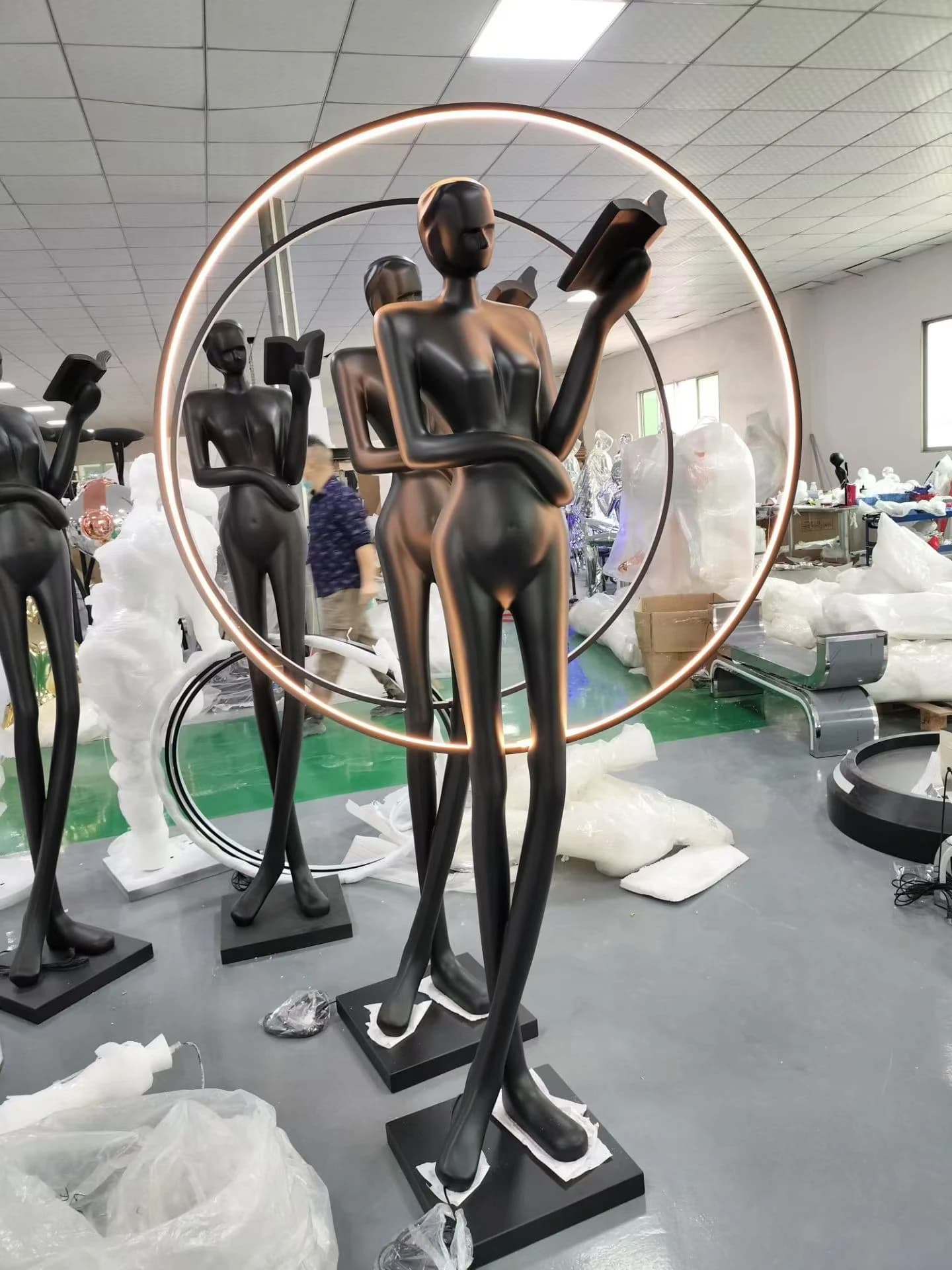 Escultura de pareja de figuras dentro de un aro de luz