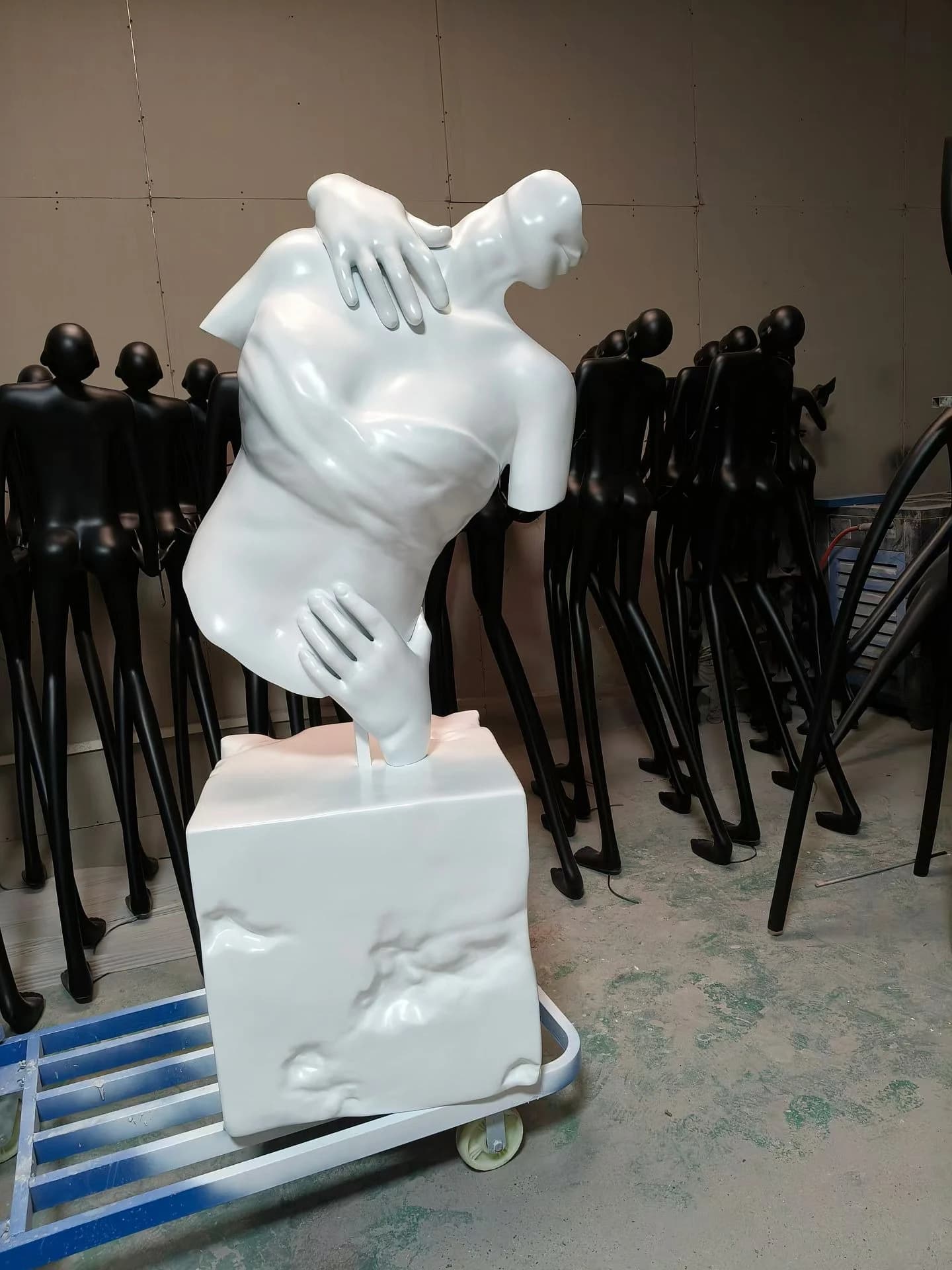 Escultura de figura blanca sobre pedestal