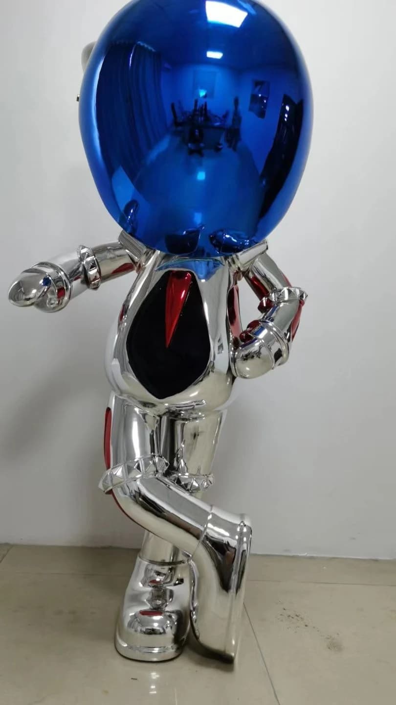 Escultura de figura plateada con casco azul espejado